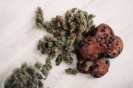 Baking with the addition of CBD. Sweets with weed. Chocolate cookies with marijuana. Sweets with cannabis. Cannabis buds on a black background.の写真素材