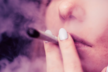 cannabis weed A woman smokes, a joint and a lighter in his hands. Smoke on a black background....