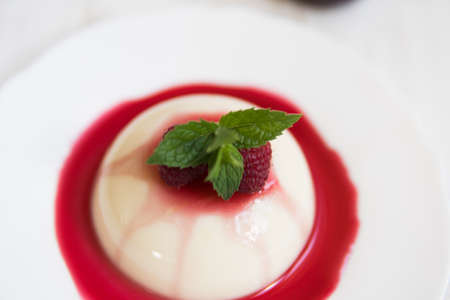 Panakota with raspberries. Vertical shot. macro . Light background. Summer dessert.の写真素材