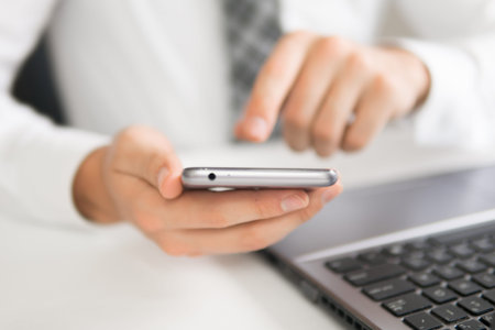 Businessman work with computer on table in office work. Holding smartphone in hand. Financial...