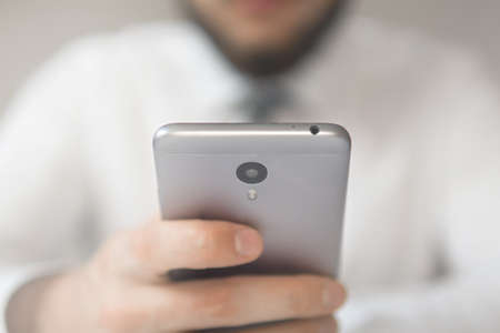 Payment of goods online. Online payments through the phone. Online trading on the currency exchange. Young businessman with a bank credit card in his hands. Smartphone and Internet Commerce.の写真素材