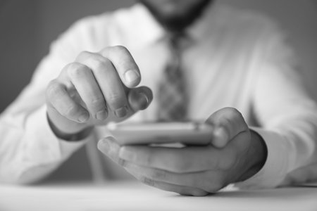 Businessman uses a smartphone Close up telephone. Sending email, mobile phone. Office work concept....