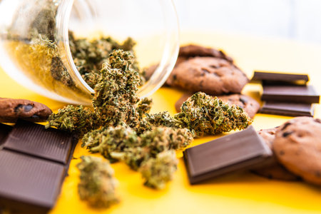 Cookies and Chocolate with cannabis and buds of marijuana on the table. Cannabis CBD herb Chocolate...