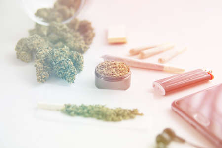 Cannabis buds on black table, grinder with fresh weed, joint with marijuana, close up, light leaks color tonesの写真素材