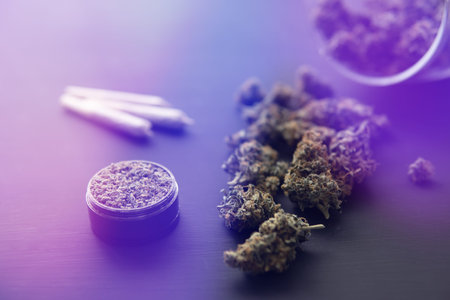 top view close up, joint with weed, Cannabis buds on black table, grinder with fresh marijuana, light leaks color tonesの写真素材