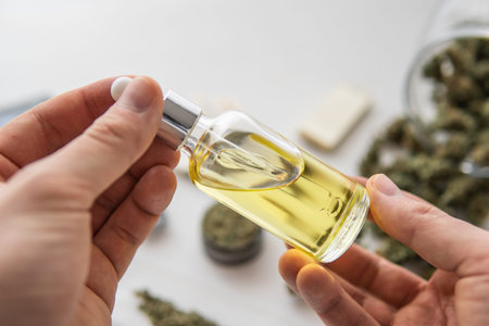 bottle of oil Cannabis in pipette in hand, hemp product, medical marijuana concept, CBD cannabis OIL...