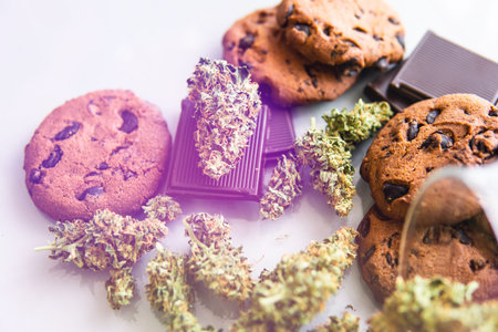 Cookies with cannabis and buds of marijuana on the table. Cookies with cannabis herb CBD.