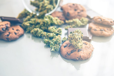Cookies with cannabis and buds of marijuana on the table. Cookies with cannabis herb CBD.Treatment...
