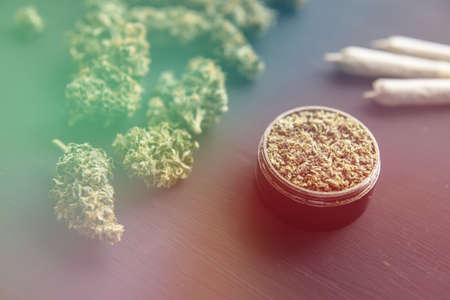 joint with weed, close up, Cannabis buds on black table, grinder with fresh marijuana, top view, light leaks color tonesの写真素材