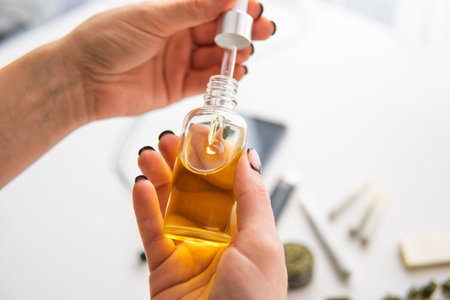 medical hemp concept, weed product, close up, oil Cannabis CBD in pipette women hand, marijuana...