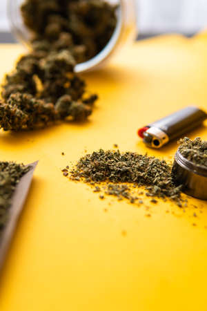 CBD and THC on buds in cannabis. Blunt and Lighters. Background for Copy space. Hemp legalisation. Fresh marihuana. Top view. Cannabis buds on yellow background.の写真素材