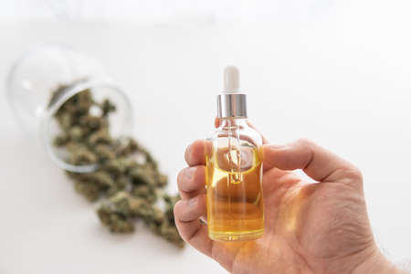 CBD cannabis OIL. close up, hemp product, bottle of Cannabis oil in pipette in hand, medical marijuana concept,の写真素材