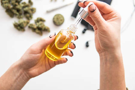 marijuana extract on white background, medical hemp concept, weed product, close up, oil Cannabis CBD in pipette women hand,の写真素材
