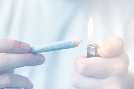 Smoking marijuana at home. Close up . Recreational use of cannabis. Man smoking weed indoor.の写真素材