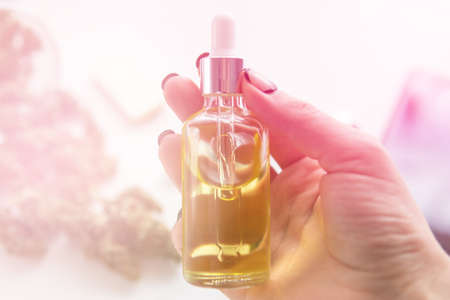 bottle of oil Cannabis in pipette in women hand, CBD cannabis OIL on white background, medical marijuana concept, close up, hemp product, light leaks color tonesの写真素材