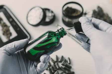 Hand holding bottle of in pipette Cannabis oil CBD cannabis OIL. hemp product, medical marijuana...