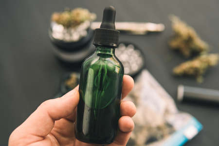 Hand holding bottle of Cannabis oil in pipette, natural herbの写真素材