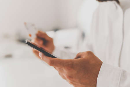 credit card and Businessman hands using Online shopping concept in morning light. using smart phone for online shopping. Online payment, smartphone and holding credit card with socialの写真素材