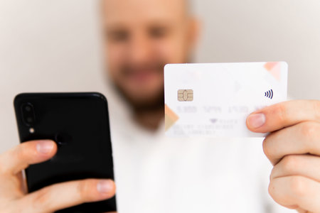 Closeup of young man making man hands using smartphone and holding credit card with social Online...