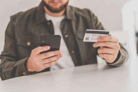 payment online shopping smartphone at working place. Buying online with a credit card and smart phone sitting home with a blurred background. hand credit card for shopping online. Web shopping.の写真素材