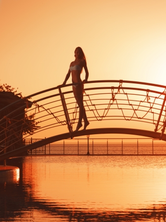 Girl on the bridge over poolの写真素材