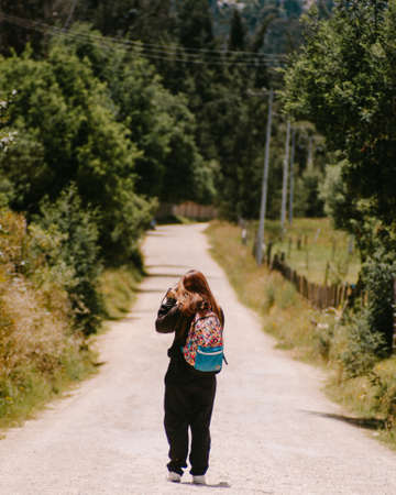 girl taking pictures in the middle of the roadの写真素材