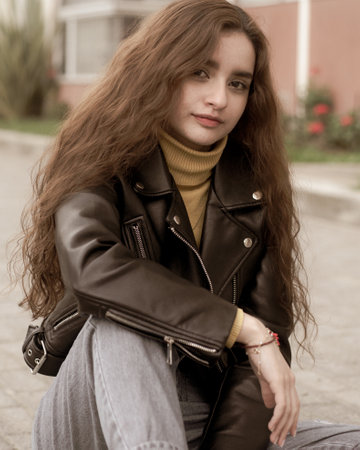 Portrait of a beautiful young woman with long hair in a leather jacketの写真素材