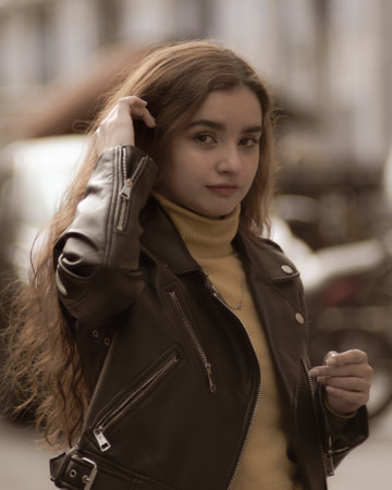 Portrait of a beautiful young woman in a leather jacket on the streetの写真素材