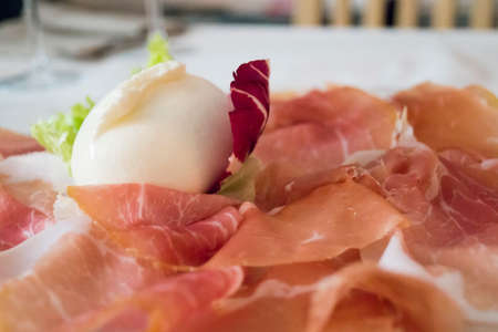 Fresh mozzarella and Parma ham PGI with green and red saladの写真素材