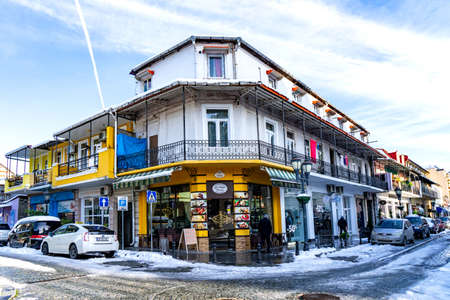 Batumi, Adjara, Georgia - 14.03.2020: the corner street with a restaurant in old quarter street with old soviet-style house residence in Batumi, Georgia. Winter snowのeditorial素材