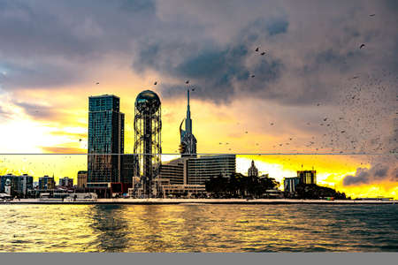 Batumi, Georgia - 09.03.2020 - Sunset in the Resort city and port at Black Sea with  seagull flyingâ city centre from sea in Black Sea, Batumi, Georgia.のeditorial素材