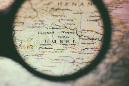 Close-up view with magnifying glass of the Chinese regions on an ancient map, photo taken in Italy,...