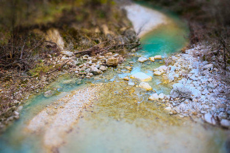 Mountain stream with turquoise water and stones in autumn forestの写真素材
