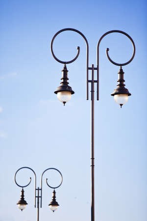 Oldfashioned decorative lamp post on the background of blue skyの写真素材