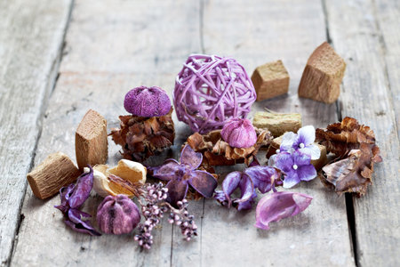 Close-up of aromatic dried flowers and other natural things on wooden surface. Potpourri used for...