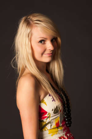 Beautiful young blonde girl with long hair posing in studio against dark background
の写真素材