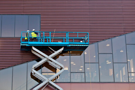 Builder on a Scissor Lift Platform at a construction site. Men at workの写真素材
