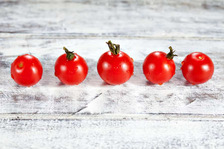 Cherry tomatoes on white painted table surfaceの写真素材