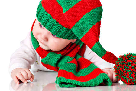 Closeup of cute little baby boy with blue eyes wearing striped Cristmas hat with pompon and scarf. More photos with same child in my portfolioの写真素材