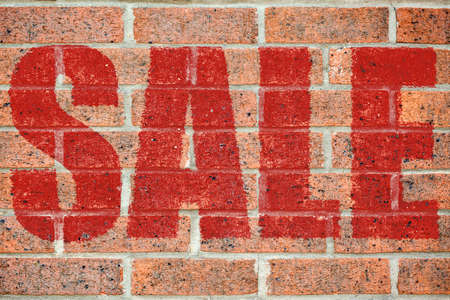 Red SALE inscription on brickwall surface pattern as a wallpaper concept for designers background applyingの写真素材