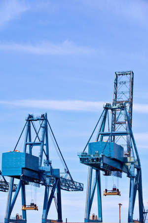 Blue cargo cranes at Sea port against sky backgroundの写真素材