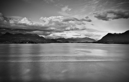 View over Lake Maggiore and Swiss Alps mountains from Italian side in Northern Italy. Monochrome in black and white.の写真素材