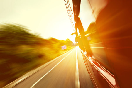 Red old bus going fast on the highway with motion blur backgroundの写真素材