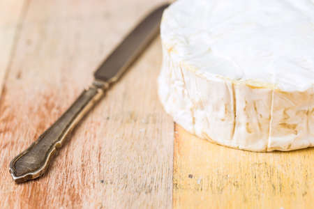 Camembert cheese and vintage knife on wooden tableの写真素材