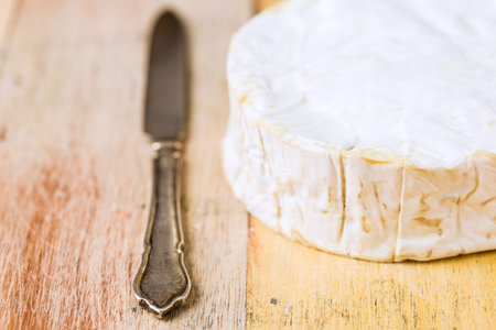 Camembert cheese and vintage knife on wooden tableの写真素材
