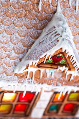Decorative gingerbread house with lights inside on black background. Rural Christmas night sceneの写真素材