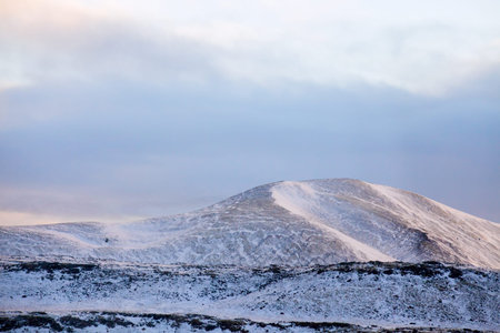 Snowy Icelandic mountains with dramatic cloudy sky - amazingly peaceful landscape of Iceland.の写真素材