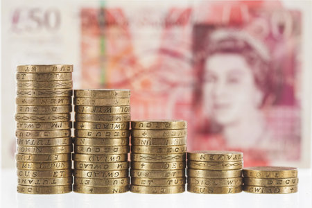 Columns of British Pound Sterling coins in decreasing heights, symbolising steep economic losses and...