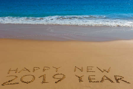 HAPPY NEW 2019 YEAR inscription written in the wet yellow beach sand. Concept of celebrating the New Year.の写真素材