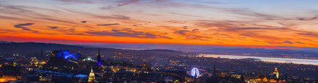 Panoramic view Edinburgh city with beautiful orange sunset sky.